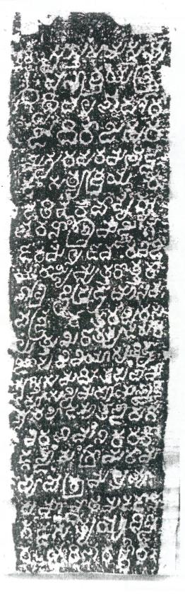 An ink impression of one narrow face of a stone. Large pale letters stand on a dark, speckled ground.