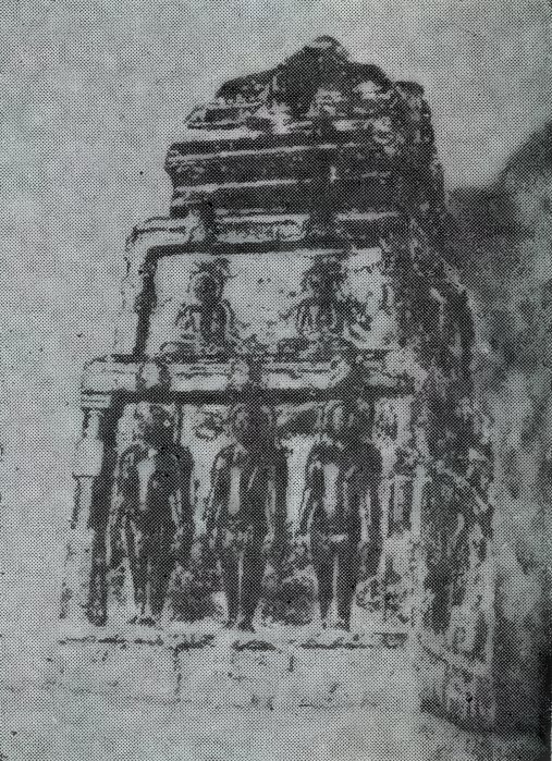 A weathered stone block shaped like a small shrine, with rows of small standing statues carved on its sides.