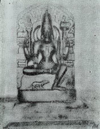 A faded photograph of a seated goddess with several arms, carved on a stone slab, with a small animal carved on the pedestal below her.