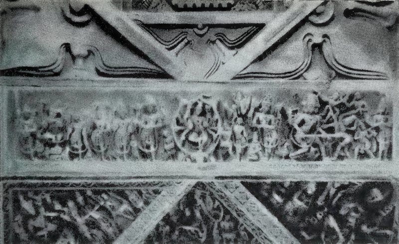 A carved stone beam with a frieze of many small statues between bands of diagonal carved panels.