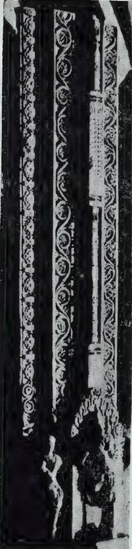A tall, narrow door jamb carved with vertical bands of scrollwork.