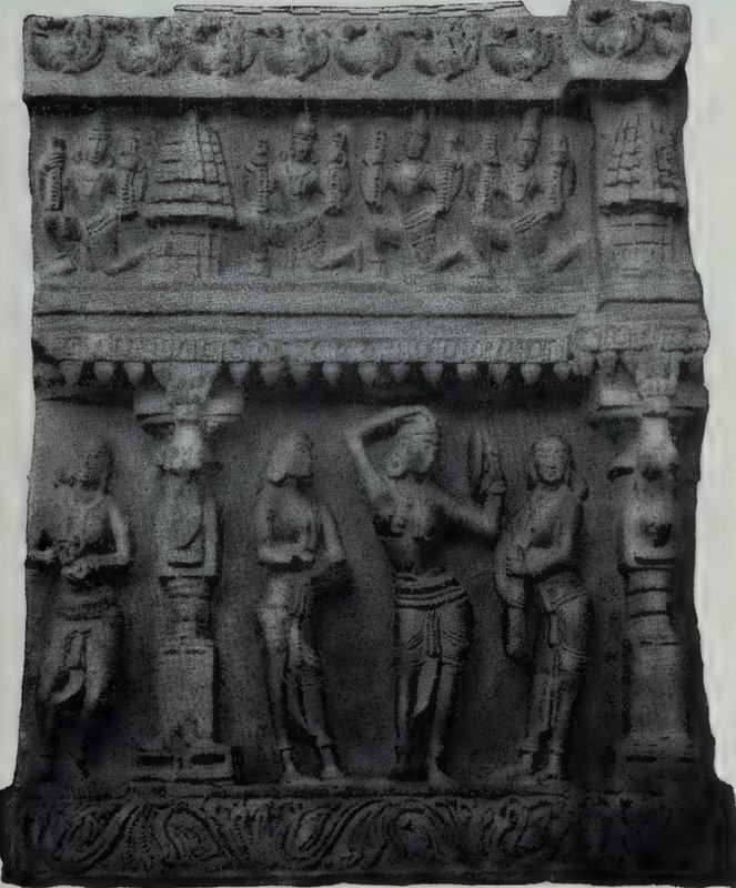 A carved stone panel with seated statues in an upper band and standing statues, one with a raised arm, in a lower band.