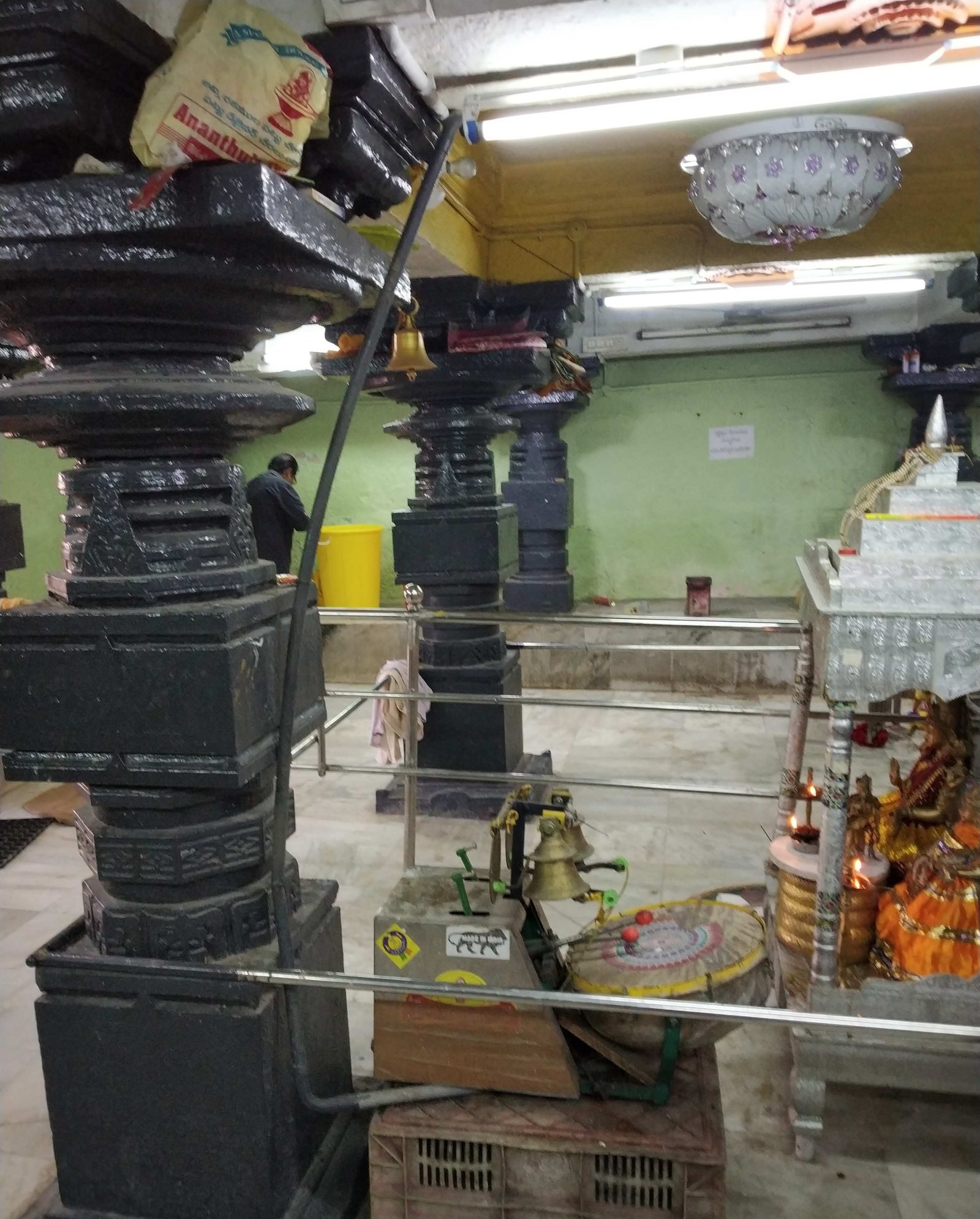 ఆలయ మందిరం లోపల, భారీ చీకటి రాతి స్తంభాలు చదరపు స్థావరాలపై నిలబడి ఉంటాయి. వాటి షాఫ్ట్లు పేర్చబడి, గుండ్రంగా మరియు చదరపు పొరలలో చెక్కబడ్డాయి. గదిలో టైల్డ్ ఫ్లోర్, పెయింట్ చేసిన ఆకుపచ్చ గోడ, ట్యూబ్ లైట్లు మరియు షాన్డిలియర్ ఉన్నాయి. కుడివైపున వెండి కప్పబడిన స్టాండ్ మీద నారింజ రంగు దుస్తులు ధరించిన పండుగ చిత్రాలు నిలబడి ఉన్నాయి.